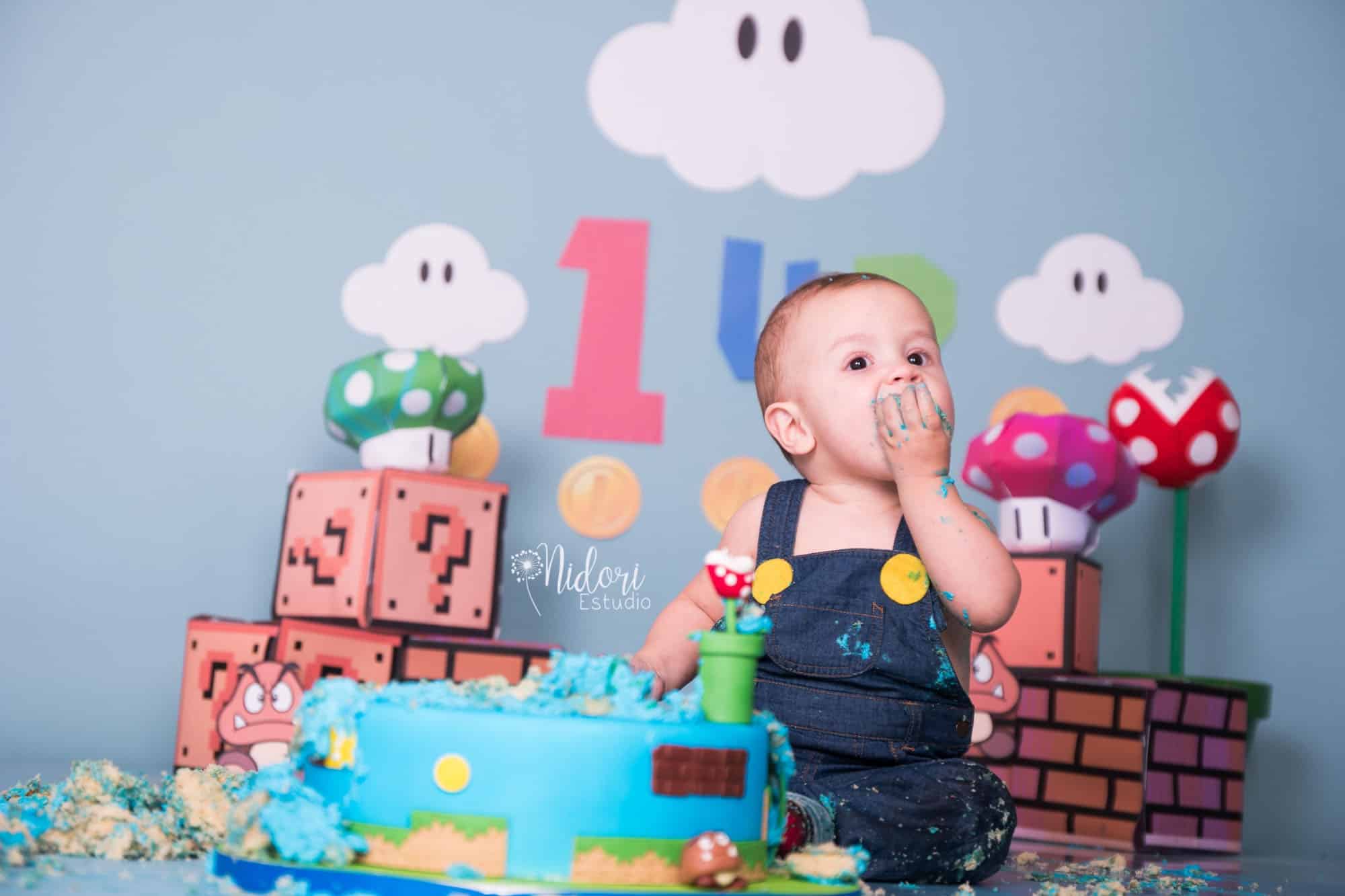 Bebé de 1 año en un estudio fotográfico con un pastel y globos